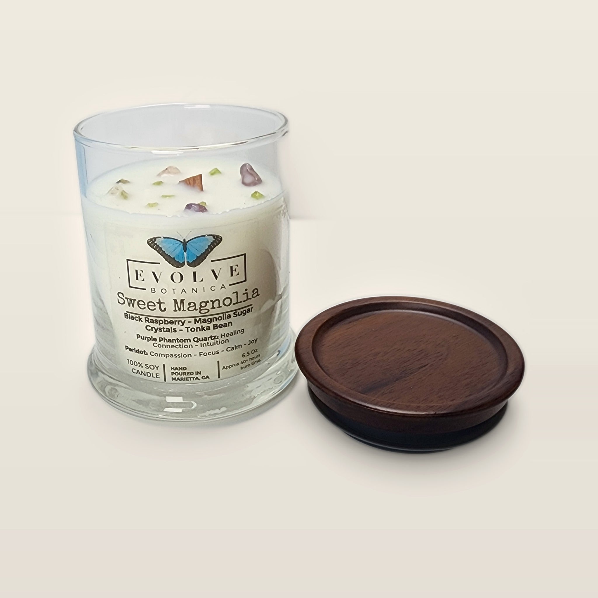 Evolve Botanica Sweet Magnolia 6.5 oz soy sipper candle open with wood lid and crystals