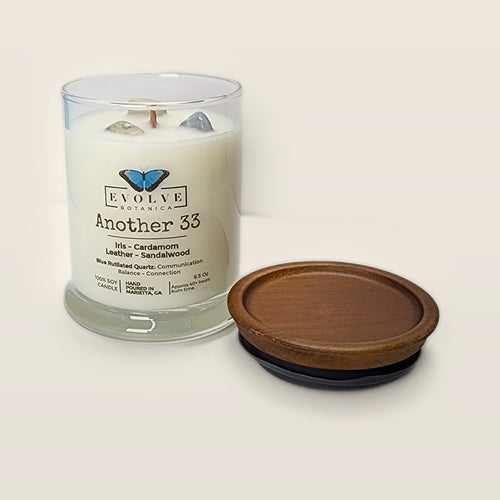 Evolve Botanica Another 33 6.5 oz soy sipper candle open with wood lid and crystals