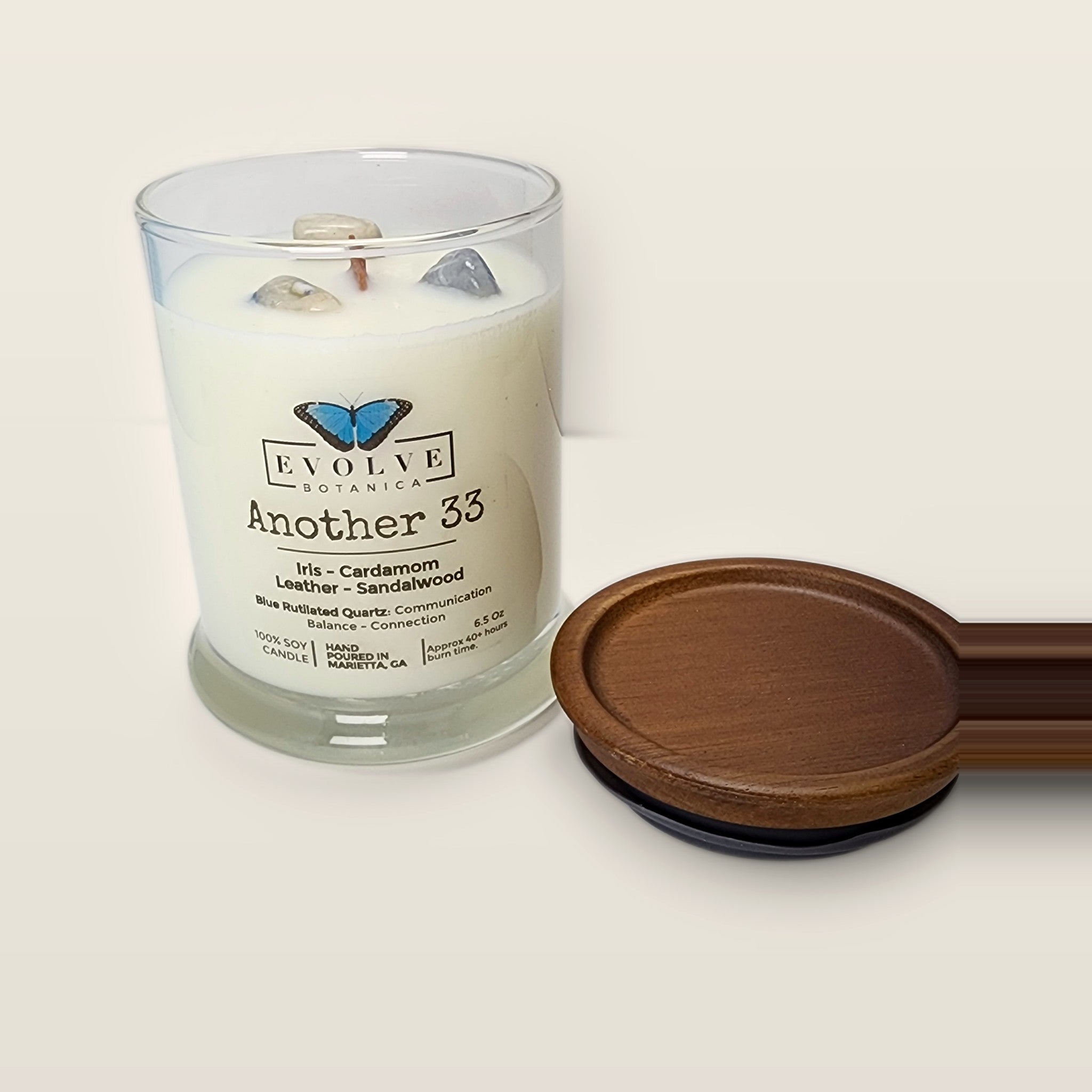 Evolve Botanica Another 33 6.5 oz soy sipper candle angled view with wood wick and crystals