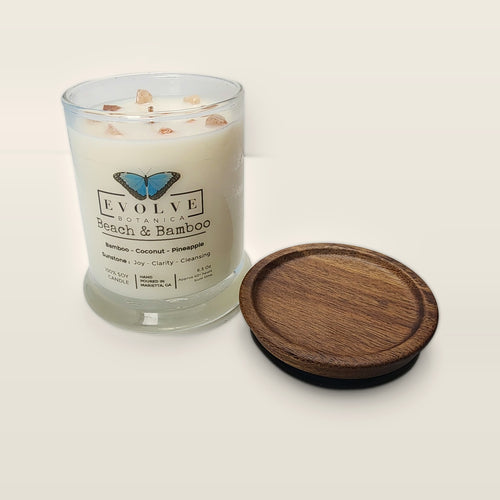 Evolve Botanica Beach & Bamboo 6.5 oz soy sipper candle open with wood lid and crystals