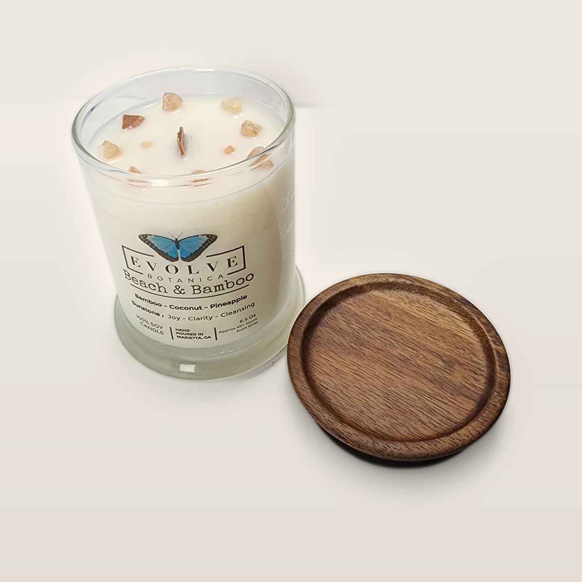 Evolve Botanica Beach & Bamboo 6.5 oz soy sipper candle angled view with wood wick and crystals