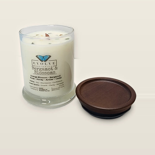 Evolve Botanica Bergamot & Blossoms 6.5 oz soy sipper candle open with wood lid and crystals