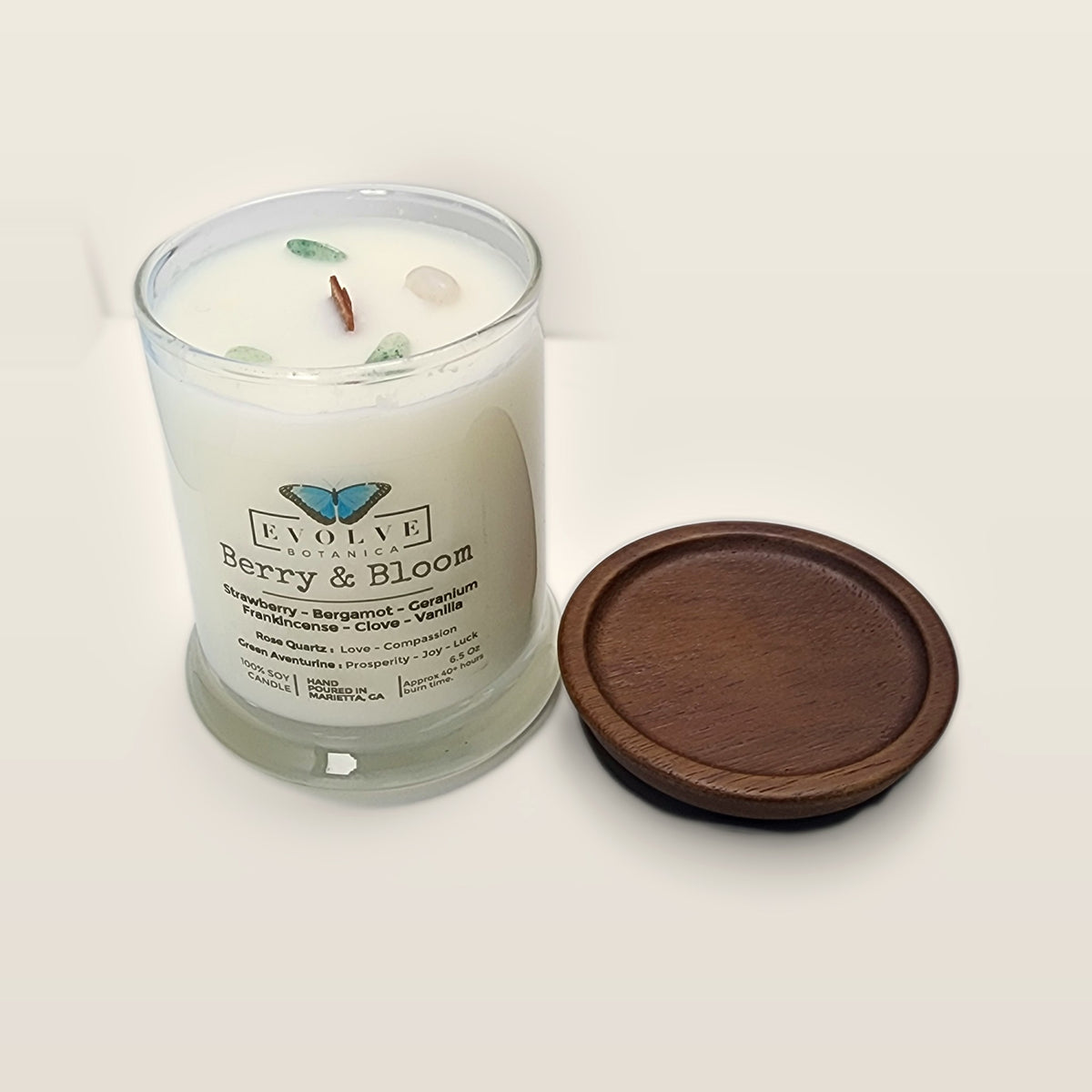 Evolve Botanica Berry & Bloom 6.5 oz soy sipper candle angled view with wood wick and crystals