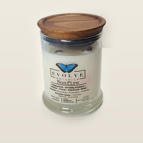 Evolve Botanica Bonfire 6.5 oz soy sipper candle open with wood lid and crystals