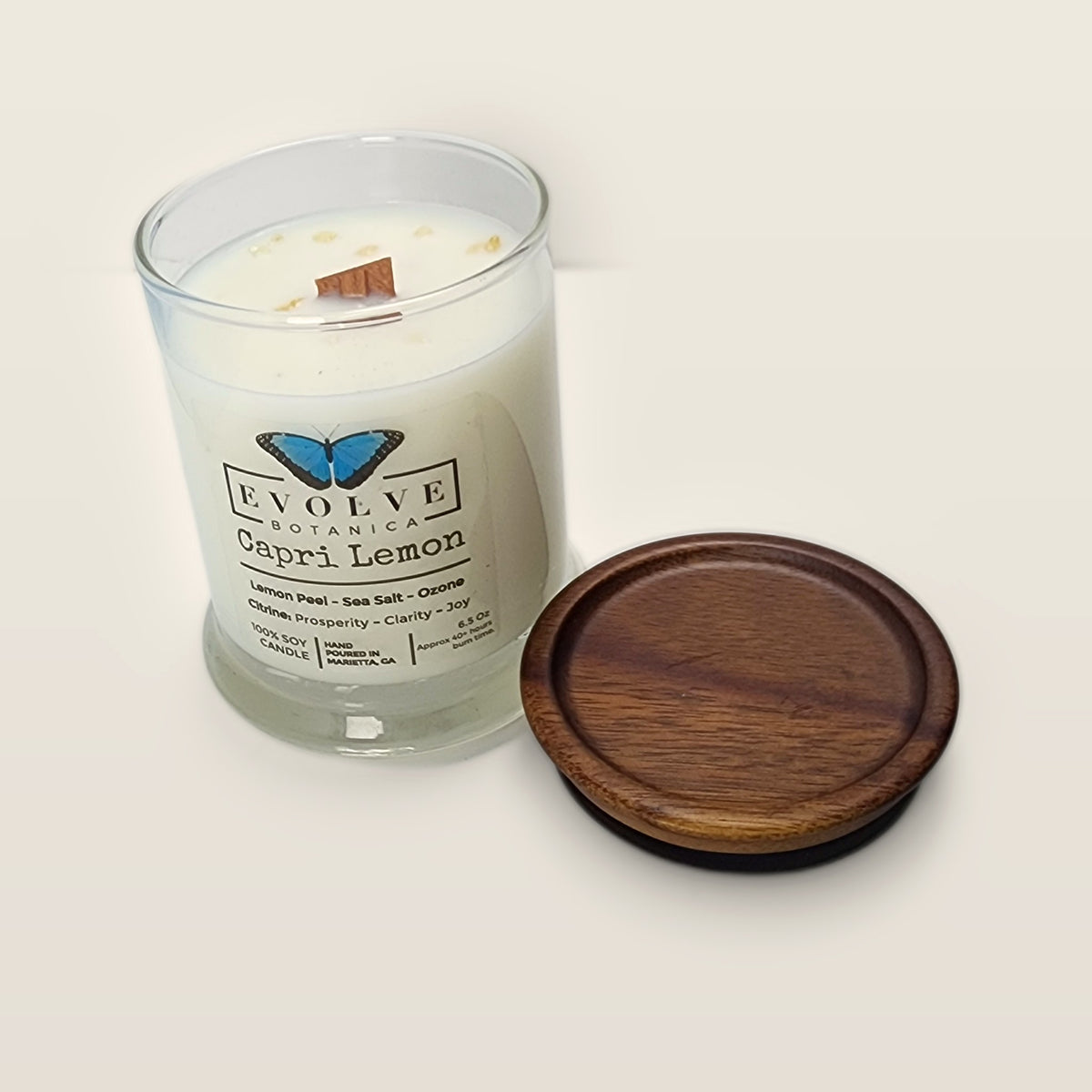 Evolve Botanica Capri Lemon 6.5 oz soy sipper candle angled view with wood wick and crystals