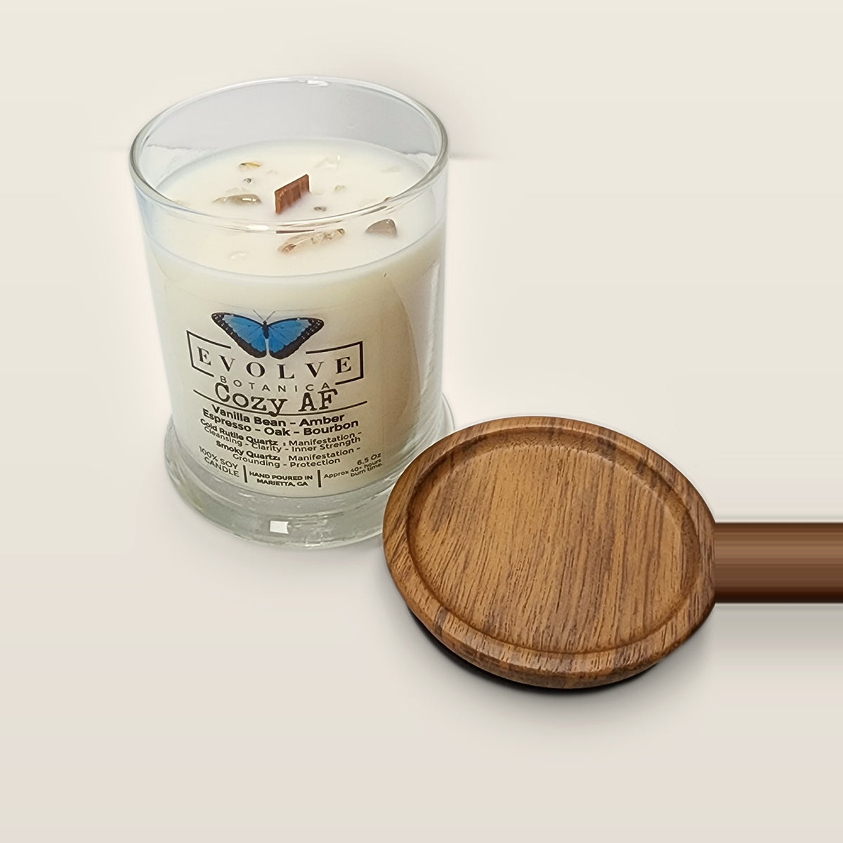 Evolve Botanica Cozy AF 6.5 oz soy sipper candle angled view with wood wick and crystals