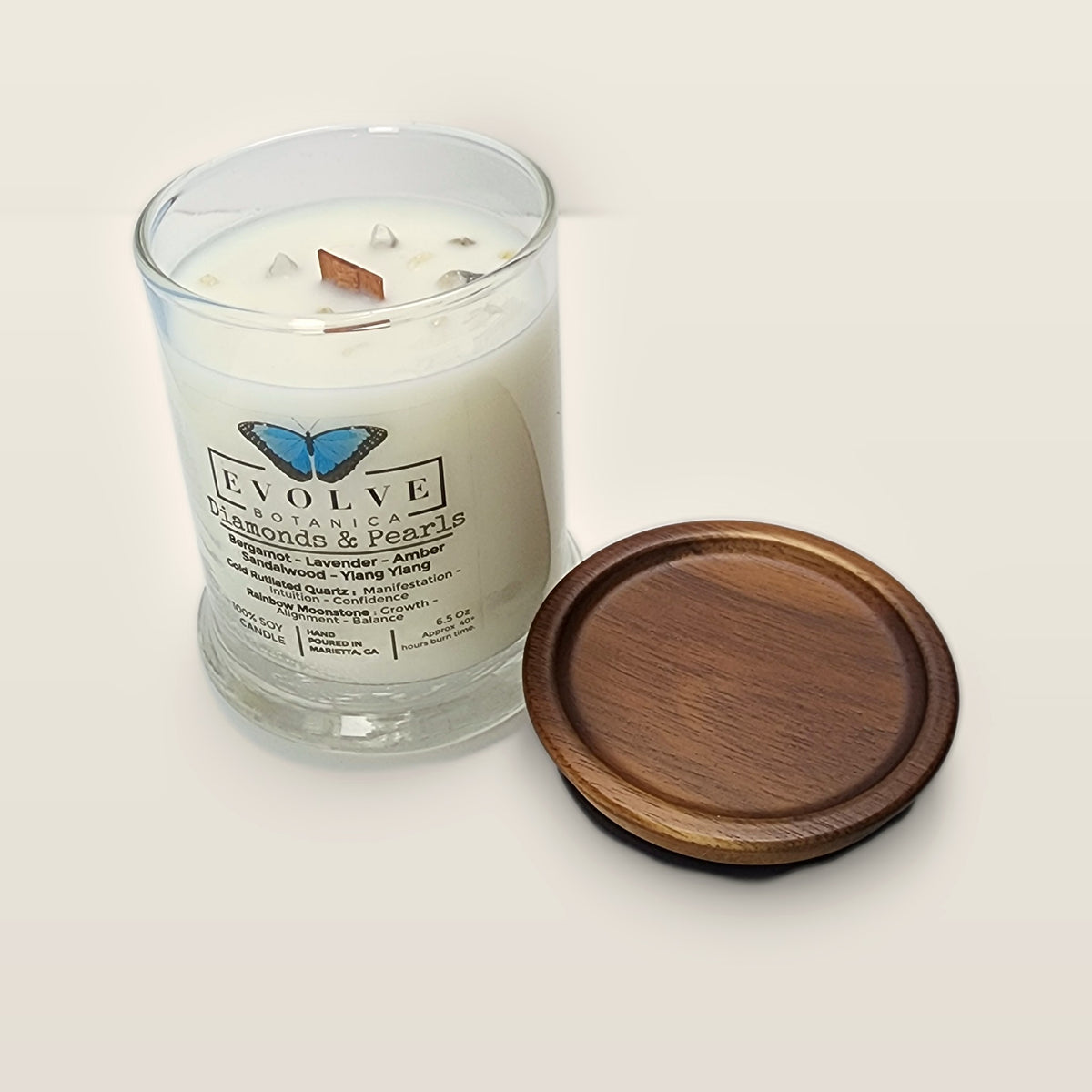Evolve Botanica Diamonds & Pearls 6.5 oz soy sipper candle angled view with wood wick and crystals