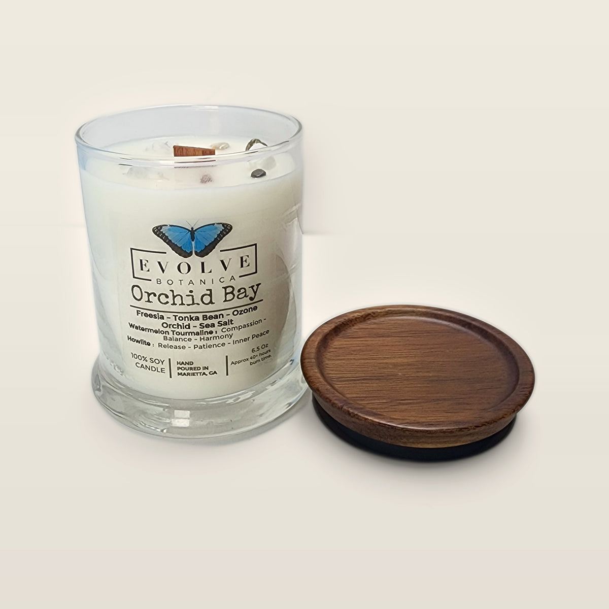 Evolve Botanica Orchid Bay 6.5 oz soy sipper candle open with wood lid and crystals
