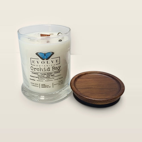 Evolve Botanica Orchid Bay 6.5 oz soy sipper candle open with wood lid and crystals