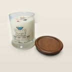Evolve Botanica Papaya & Paradise 6.5 oz soy sipper candle open with wood lid and crystals