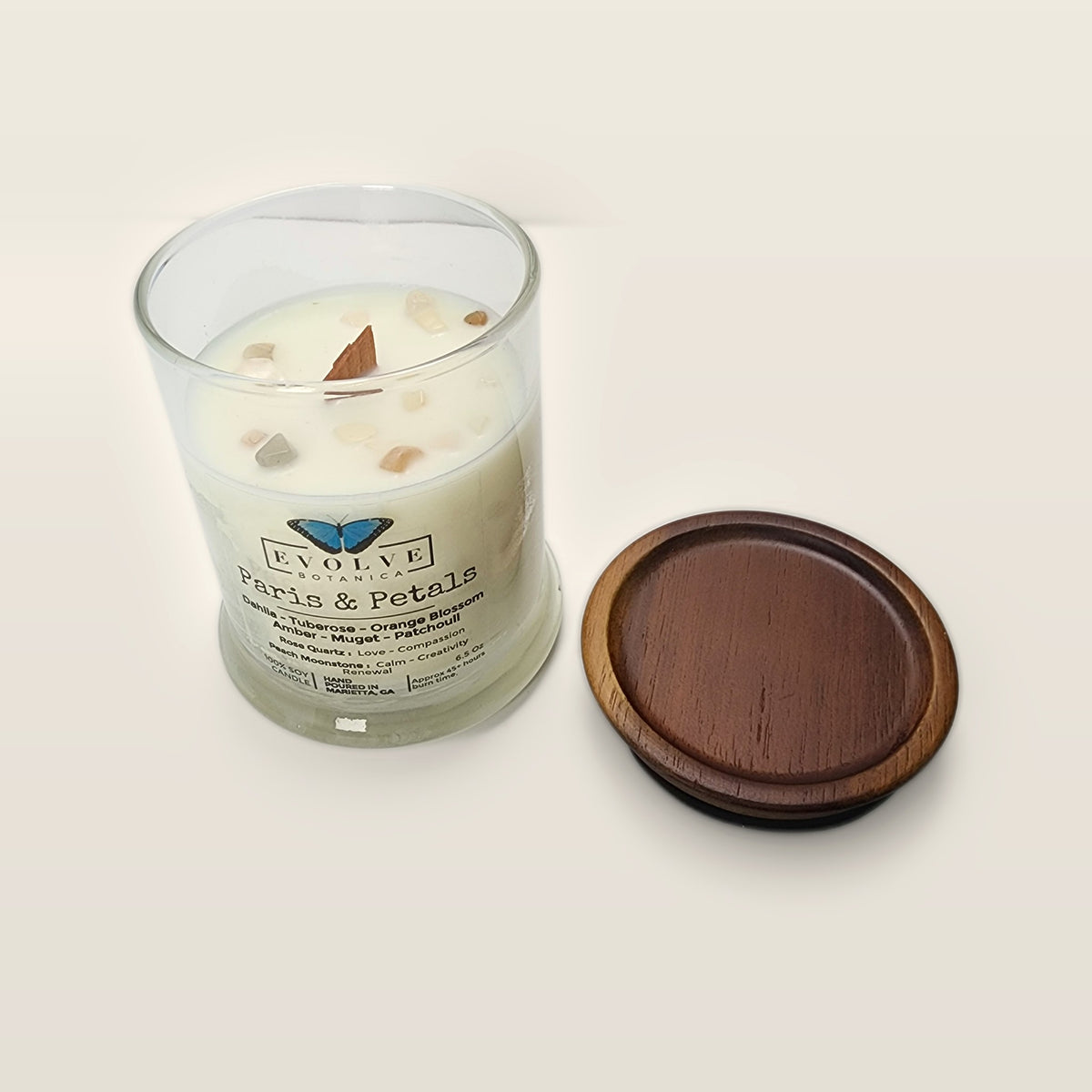 Evolve Botanica Paris & Petals 6.5 oz soy sipper candle angled view with wood wick and crystals