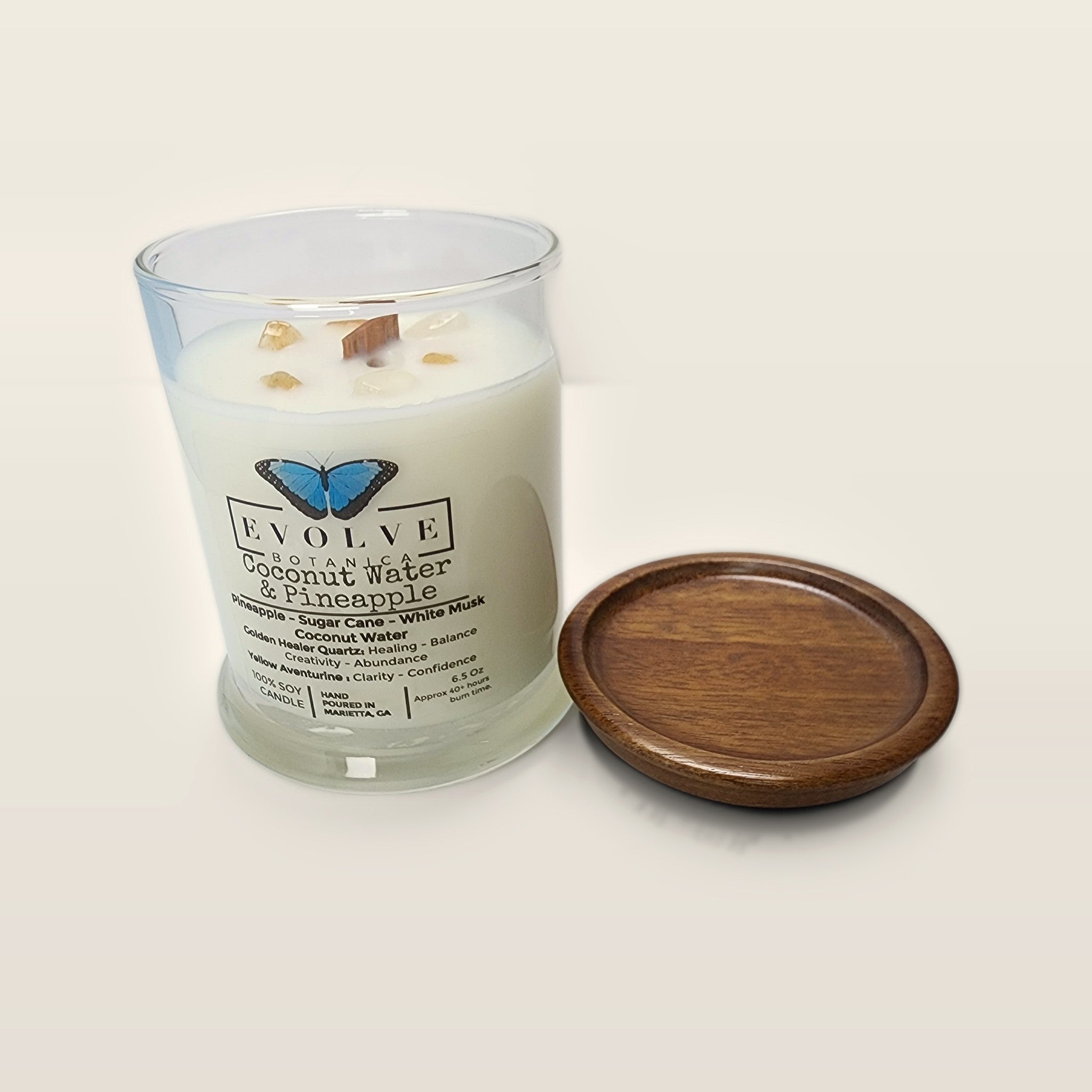 Evolve Botanica Coconut & Pineapple 6.5 oz soy sipper candle open with wood lid and crystals