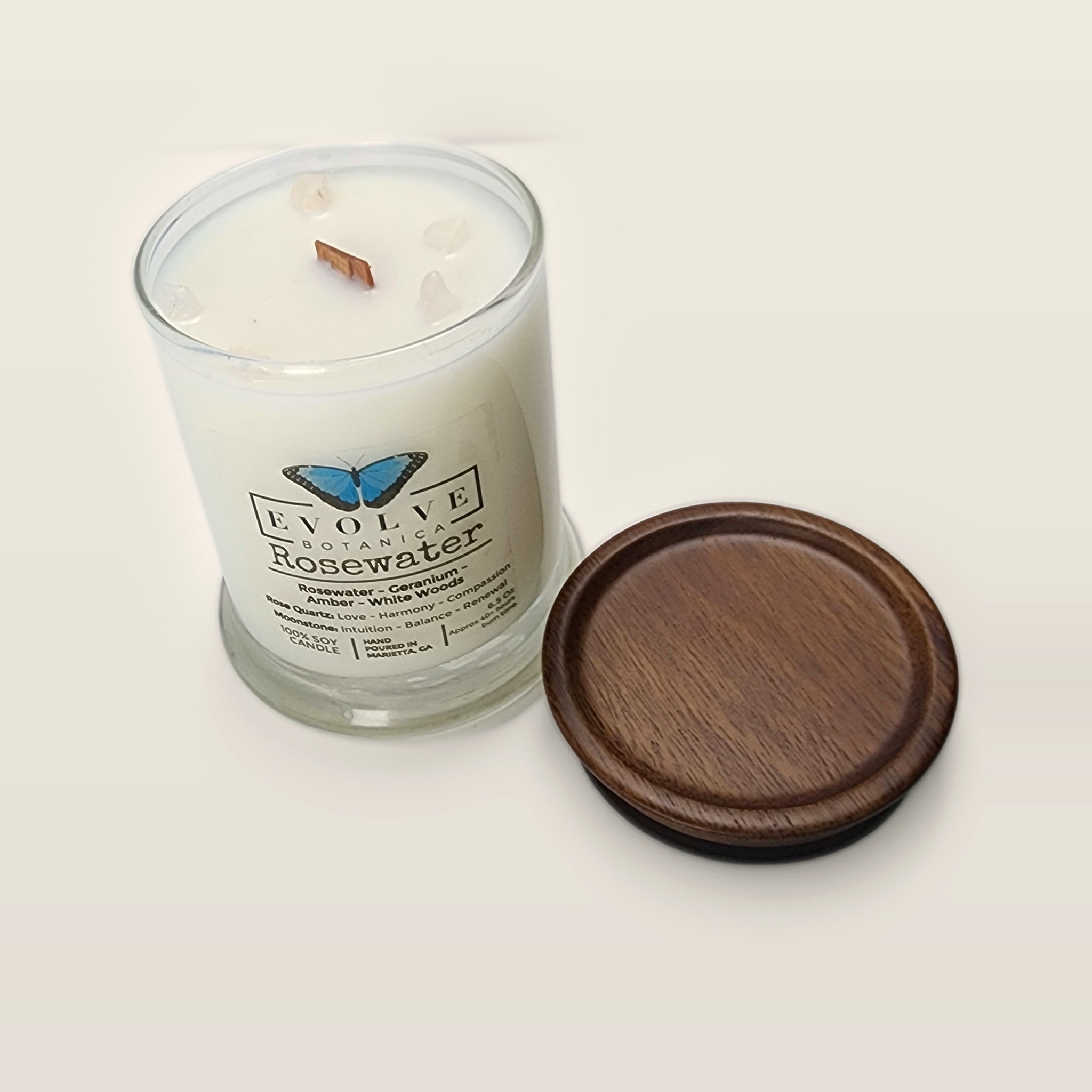 Evolve Botanica Rosewater 6.5 oz soy sipper candle angled view with wood wick and crystals