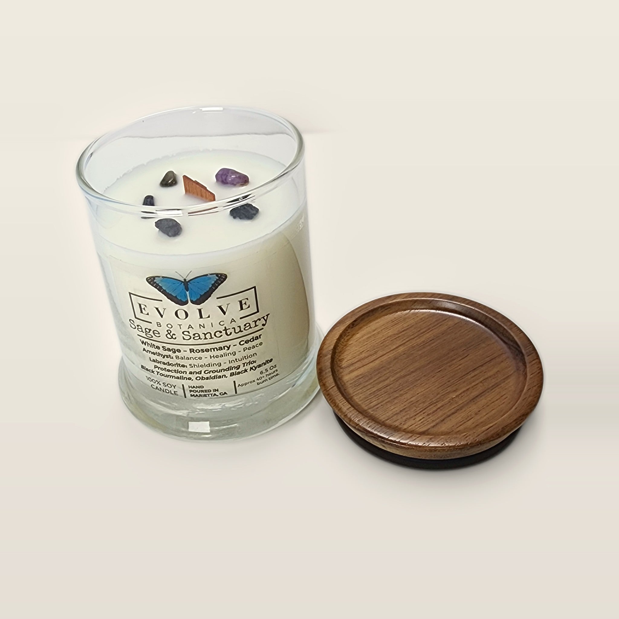 Evolve Botanica Sage & Sanctuary 6.5 oz soy sipper candle open with wood lid and crystals
