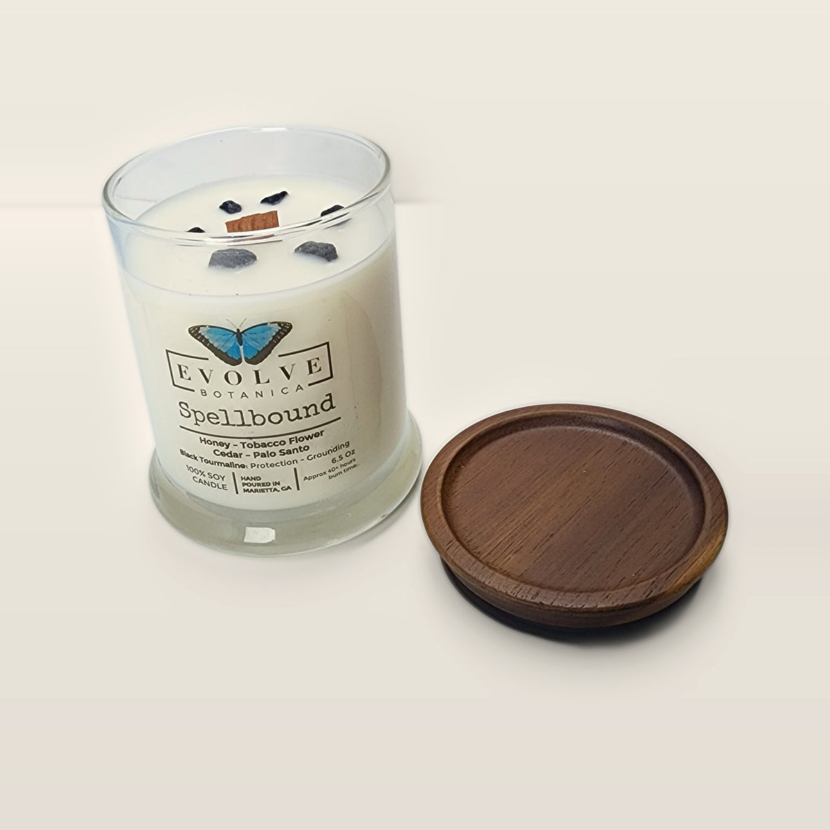 Evolve Botanica Spellbound 6.5 oz soy sipper candle open with wood lid and crystals