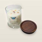 Evolve Botanica Warm Wishes 6.5 oz soy sipper candle angled view with wood wick and crystals