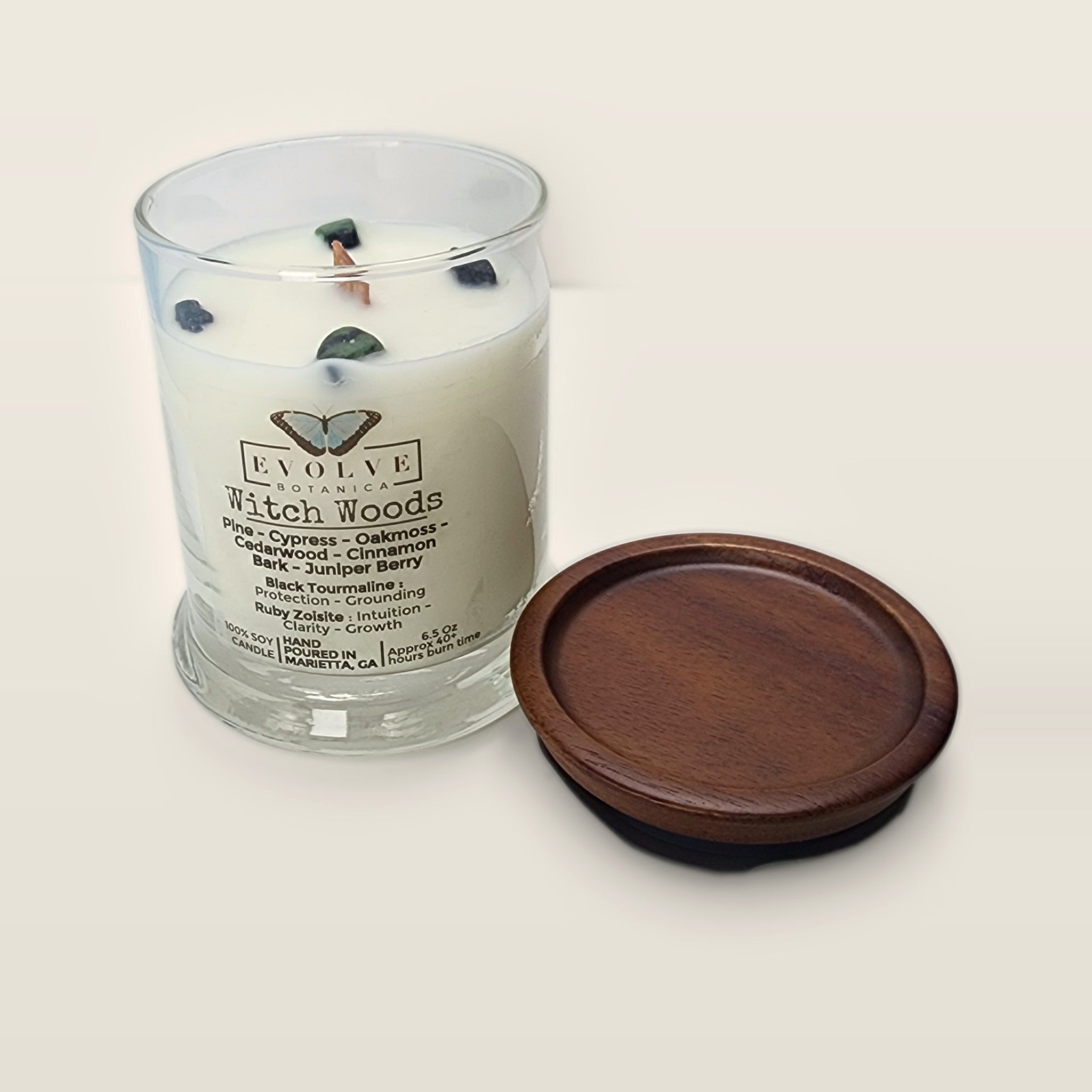 Evolve Botanica Witch Woods 6.5 oz soy sipper candle open with wood lid and crystals