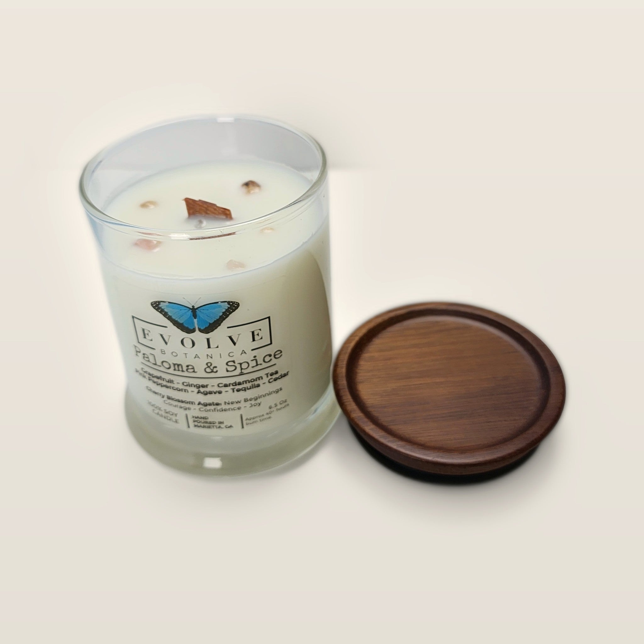 Evolve Botanica Paloma & Spice 6.5 oz soy sipper candle angled view with wood wick and crystals