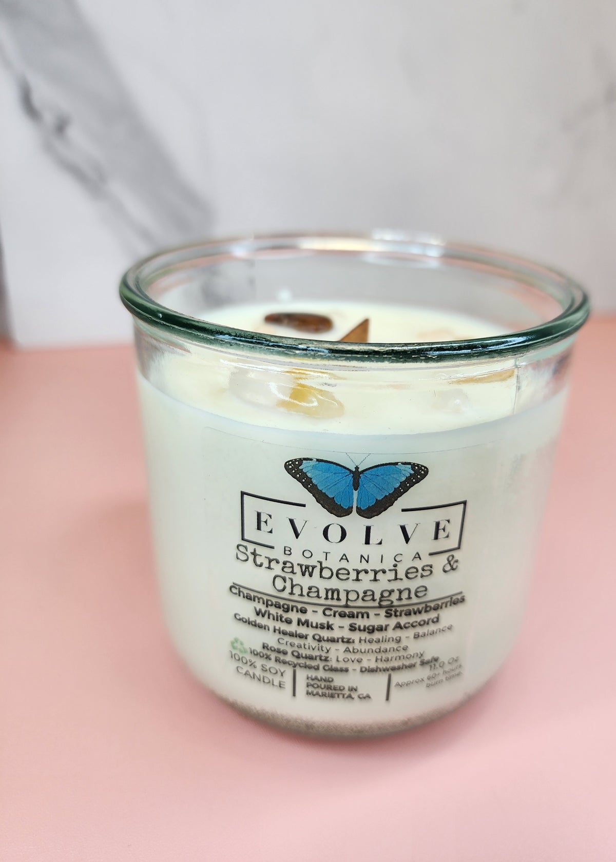 Strawberries & Champagne Rocks candle on pink and marble — white musk and sugar accord wood wick soy candle with golden healer quartz and rose quartz