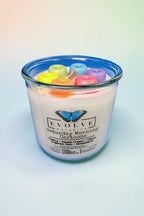 Close-up of handcrafted rainbow wax cereal loops on top of a hand-poured soy candle