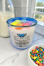 Cereal scented soy candle styled on a kitchen counter with a bowl of cereal and morning light