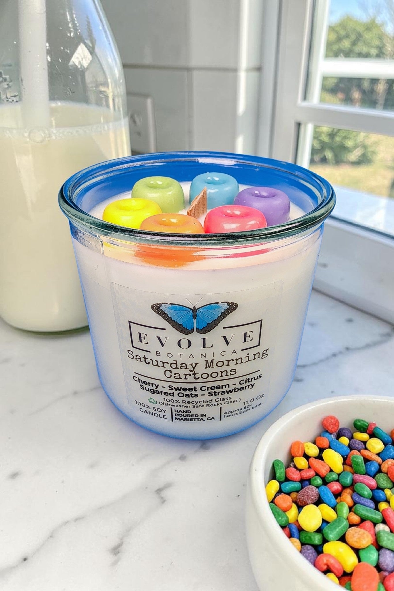 Cereal scented soy candle styled on a kitchen counter with a bowl of cereal and morning light