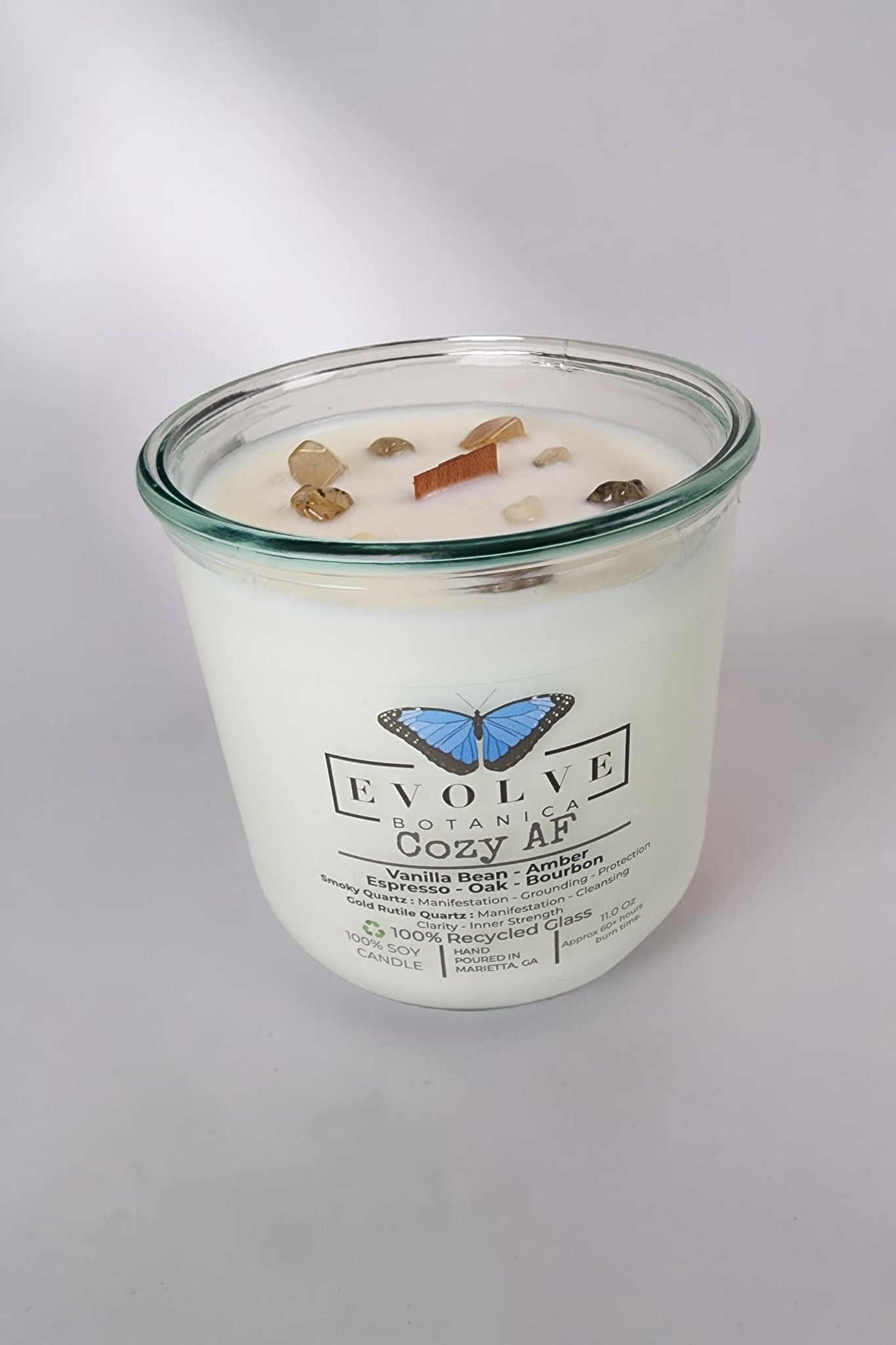Evolve Botanica Cozy AF Rocks Candle — wood wick soy candle topped with Gold Rutilated Quartz and Smoky Quartz, scented with espresso, bourbon, amber, oak and vanilla bean