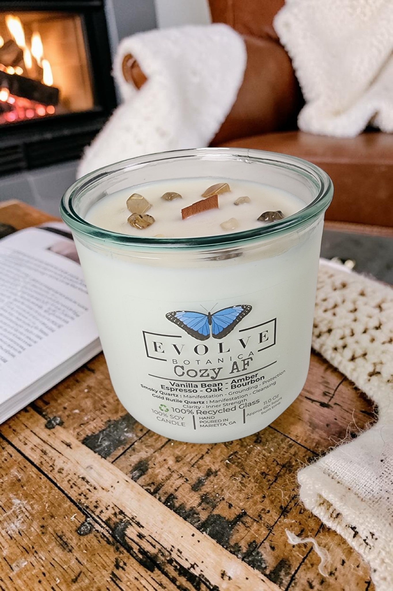 Evolve Botanica Cozy AF Rocks Candle — wood wick soy candle topped with Gold Rutilated Quartz and Smoky Quartz, scented with espresso, bourbon, amber, oak and vanilla bean