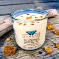 Driftwood Rocks candle with Tiger Eye crystal — coastal amber and ozone scent