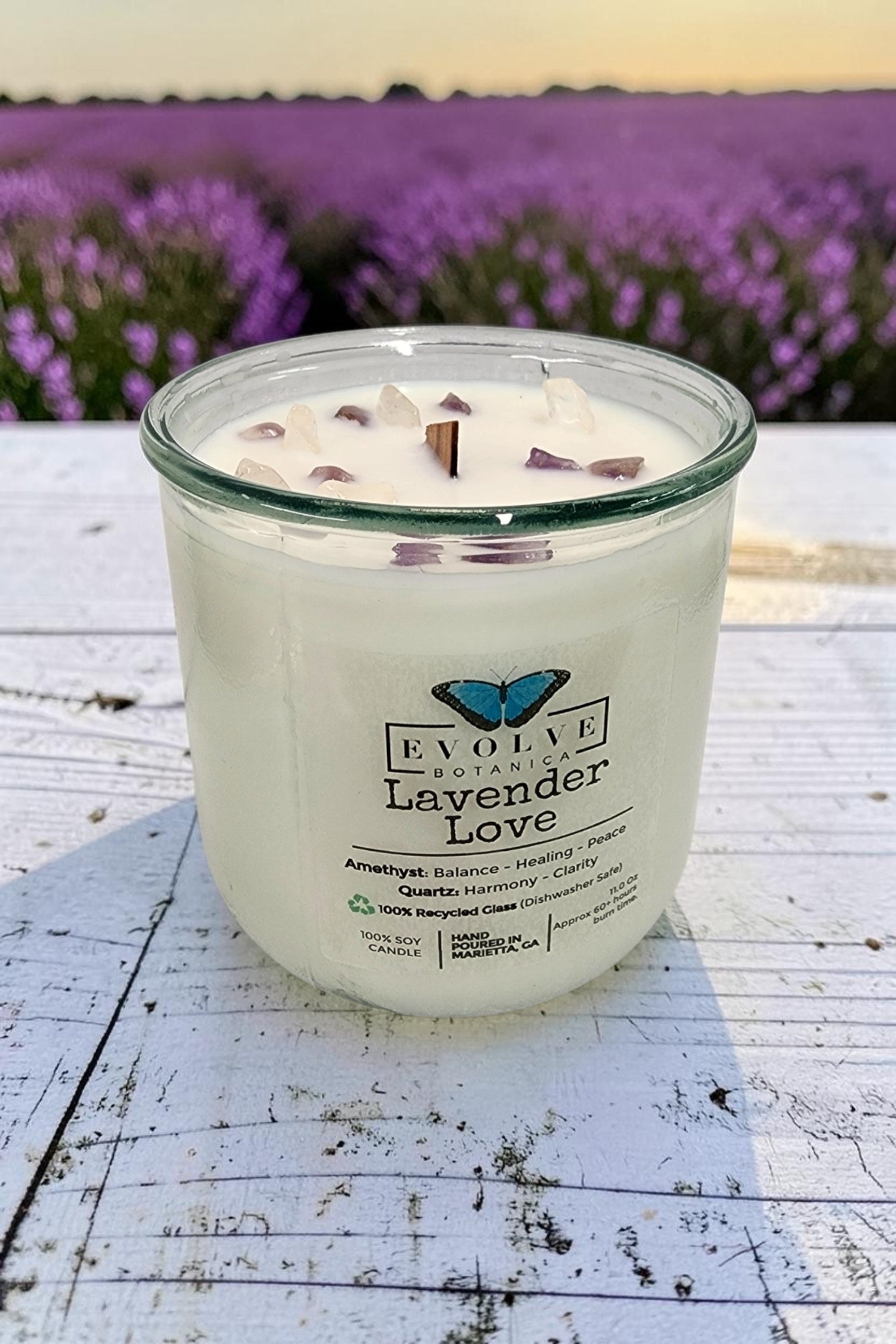 Lavender Love Rocks candle on weathered white wood in a lavender field — pure lavender soy candle with amethyst and quartz topper, Evolve Botanica