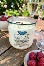 Strawberries & Champagne Rocks candle outdoors with champagne and a bowl of strawberries — celebratory soy candle, Evolve Botanica