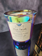 Close-up of Plot Twist Chapter One 12 oz layered candle label, Begins With Belladonna & Brandy, Turns Into Saffron & Suede, in iridescent glass