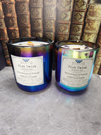 Plot Twist Chapter One in both sizes, 13.5 oz iridescent black glass and 12 oz color-shifting glass, Belladonna & Brandy to Saffron & Suede layered wood wick candles