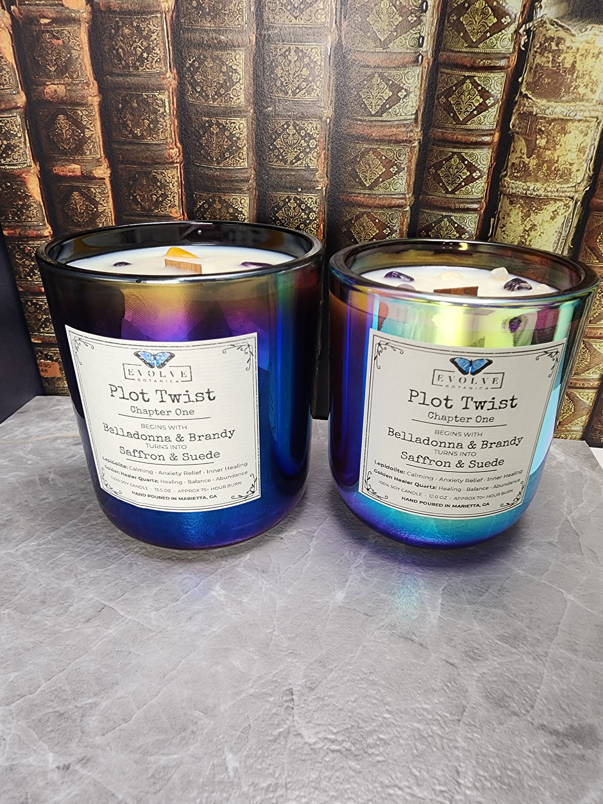 Plot Twist Chapter One in both sizes, 13.5 oz iridescent black glass and 12 oz color-shifting glass, Belladonna & Brandy to Saffron & Suede layered wood wick candles