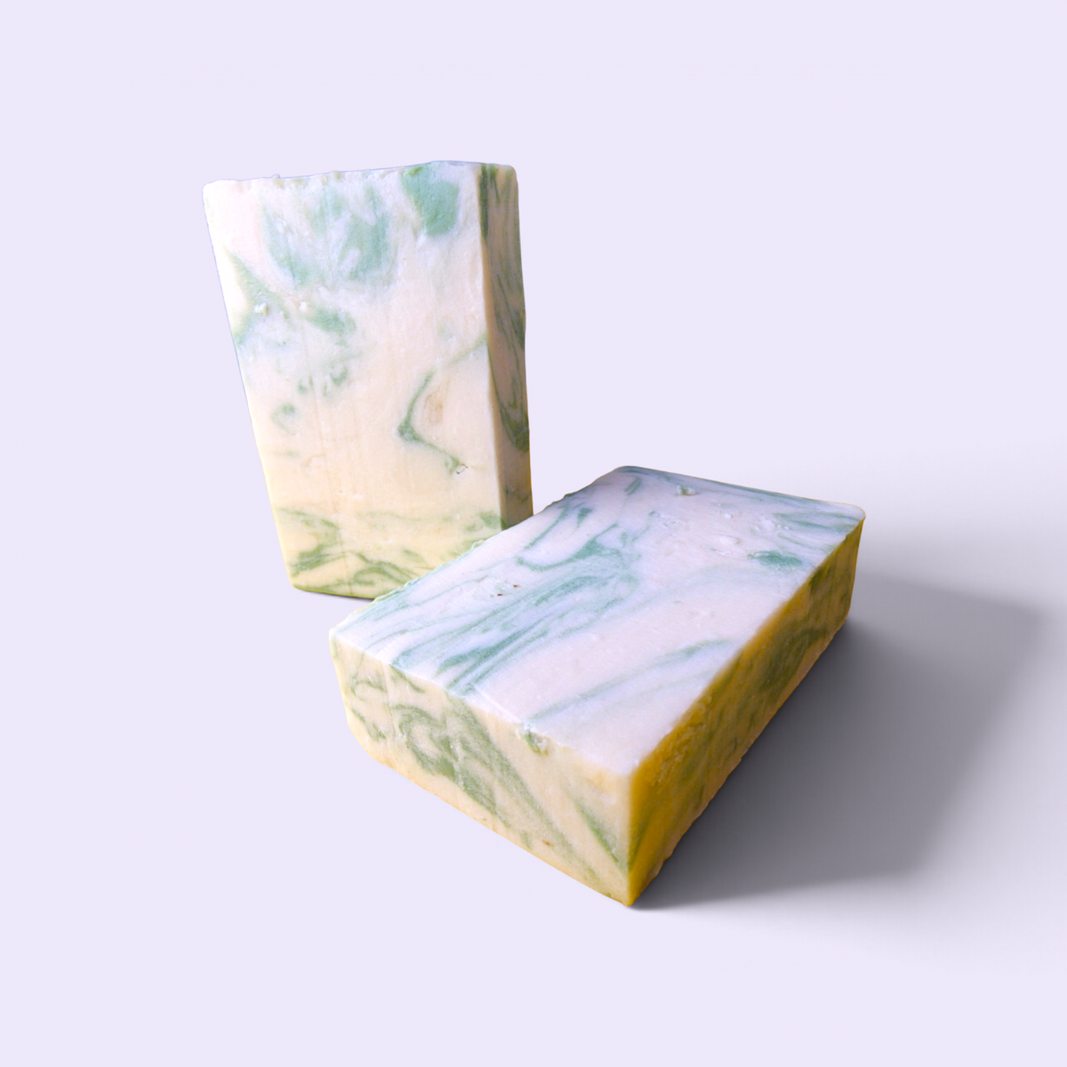 Two Silver Spruce handmade soap bars on a plain light background showing the green and cream swirl pattern